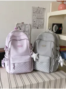 Deux sacs à dos lavande et gris, avec poches avant à étoiles et breloques suspendues