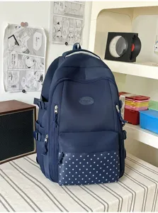 Vue de face des compartiments zippés et de la poche à étoiles sur le sac bleu marine