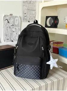 Détail de la poche à étoiles du sac à dos noir, avec fermetures éclair et breloque étoile blanche