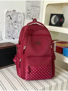 Sac bordeaux posé sur une table, avec une poche avant à étoiles et une poignée en corde tressée