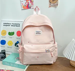 Vue de face montrant les broderies d’étoiles et d’ours, la poche avant et les cordons du sac