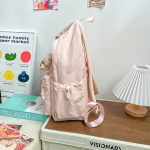 Sac à dos rose pâle pour élèves, brodé d’un cœur, avec poche à cordon et peluche, vue de côté