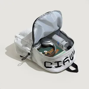 Sac à dos scolaire blanc en tissu, motif étoilé en relief et lettres noires, ouvert avec des affaires