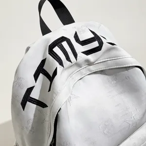 Sac à dos scolaire blanc avec lettres brodées noires, jacquard étoilé et bretelles noires