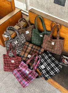 Plaid and leopard-print tote bags grouped together, with varied colors and visible fabric textures