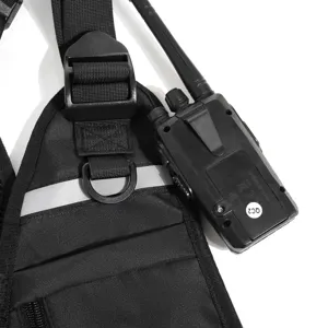 Black nylon tactical chest pack with reflective strip, adjustable straps and a radio shown beside it