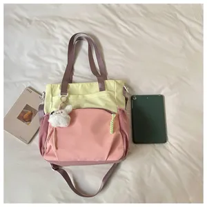 Vue à plat d’un sac rose et jaune avec pendentif lapin en peluche et bandoulière réglable
