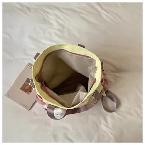 Vue plongeante sur un cabas ouvert aux couleurs contrastées, avec doublure beige et ouverture zippée