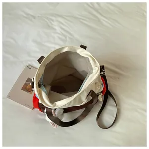 Vue de dessus du sac ouvert, révélant sa doublure en maille claire et ses anses tissées brunes