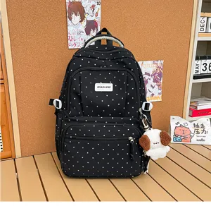 Sac à dos noir à pois blancs, deux poches zippées et porte-clés chien en peluche visible