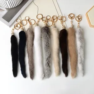 Charm a coda in morbida pelliccia, in vari colori, con moschettoni dorati e dettagli di strass
