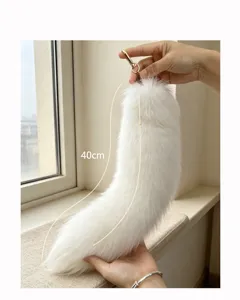 Hand-held view of a soft white faux-fur tail, 40 cm long, with a gold-tone hanging hook