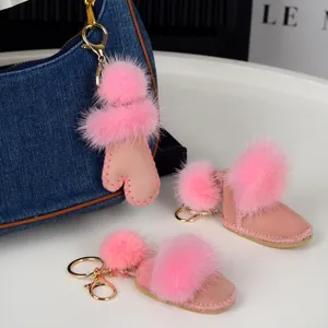 Gros plan sur la fourrure rose des breloques gant et bottines, avec des mousquetons dorés