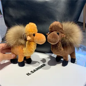 Two plush camel charms in tan and brown, with fluffy fur tufts and metal key rings on display