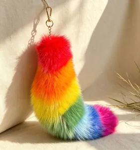 Rainbow faux-fur tail charm with vivid colors, gold-tone chain and clasp in soft natural light