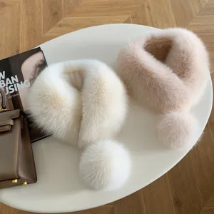 Overhead view of plush white and blush-pink fur collars with matching pom-pom accents on a table