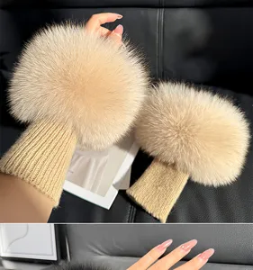 Close-up of fluffy beige fur cuffs paired with ribbed knit wrist sleeves, shown worn on hands
