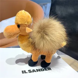 Side view of a plush camel showing its soft yellow body, black feet, and fluffy brown hump.
