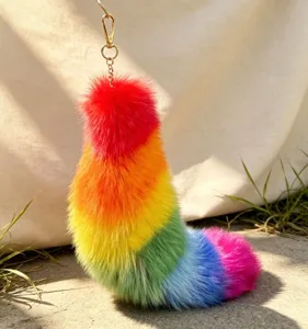 Close-up of vivid rainbow faux fur with a gold-tone chain and clasp against a sunlit background