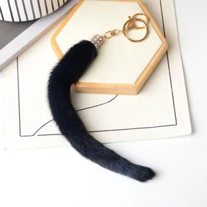 Dettaglio della coda in pelliccia blu scuro, con elemento dorato con strass e anelli