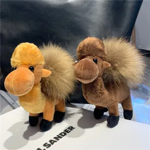Close-up of two plush camel toys in yellow and brown, with shaggy light-colored humps