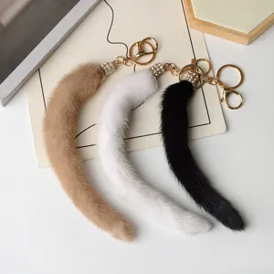 Tre portachiavi a forma di coda, beige, bianco e nero, con raccordi strassati e moschettoni in metallo