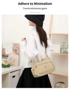 Vista laterale di una modella con borsa beige a tracolla, tasca con zip e spallina regolabile