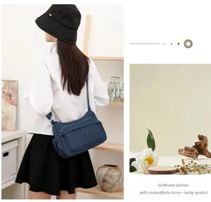 Vista da dietro di una donna con borsa blu navy, tasca frontale con zip e tracolla regolabile