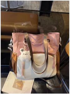 Détail du cabas rose, crème et marron avec son pendentif ourson en peluche et tirette tressée