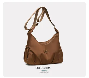 Vue de côté d’un sac marron froncé avec bandoulière tissée beige et détail rond en métal