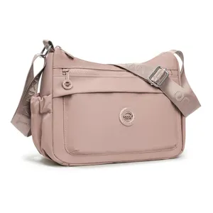 Borsa rosa in nylon leggero con tracolla regolabile, tasche con zip e tasca laterale in rete.
