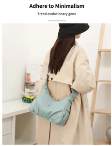 Vue de dos d’une personne portant un sac en nylon bleu-vert clair froncé, avec bandoulière réglable