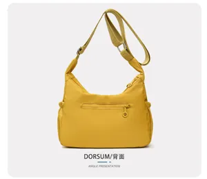 Vue arrière d’un sac jaune en nylon, avec sangle réglable et poche zippée horizontale
