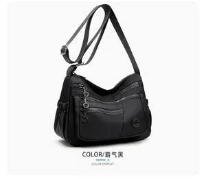 Sac noir à poches zippées, bandoulière réglable, poche latérale et breloques métalliques