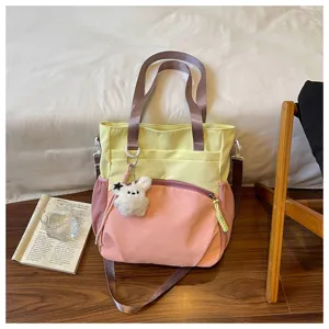 Sac en tissu jaune et rose, avec un charm lapin en peluche et une bandoulière amovible réglable