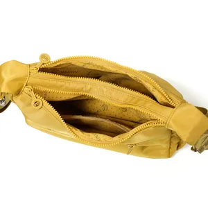 Sac bandoulière jaune en nylon ouvert, avec plusieurs compartiments zippés et sangle réglable