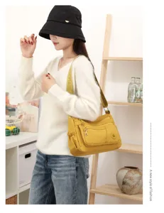 Modèle portant un sac jaune moutarde à poches multiples et bandoulière réglable en intérieur