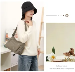 Scène portée montrant un sac en nylon gris olive à poches multiples et large bandoulière