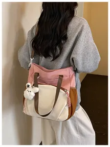 Vue arrière du sac rose, crème et caramel, avec anses brunes et ourson blanc en peluche suspendu