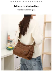 Sac brun porté, poches zippées superposées et bouton métallique rond en intérieur lumineux