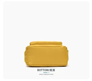 Vue du dessous d’un sac jaune en tissu, avec une base plate et rigide et des coutures latérales visibles