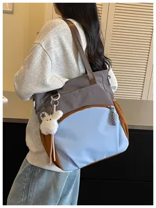 Sac porté à l’épaule, bleu, gris et brun, avec panneaux contrastés et un lapin en peluche