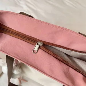 Cabas rose à empiècements contrastés, intérieur spacieux, fermeture éclair brune et doublure tissée