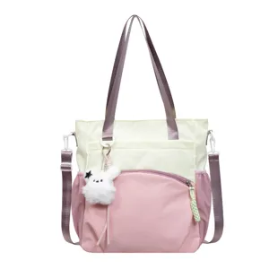 Sac cabas en nylon bicolore crème et rose, vue de face avec bandoulière et porte-clés lapin