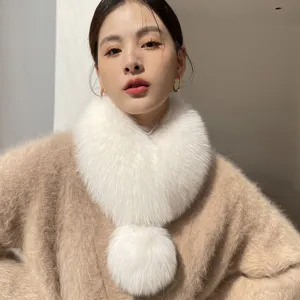 Woman wearing a white fluffy faux-fur winter scarf with a round pom-pom accent for a cozy look