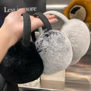 Close-up of three fluffy earmuffs in black, mottled gray and pale gray with fabric headbands
