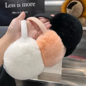 Close-up of round plush earmuffs in white, peach and black with flexible matching headbands