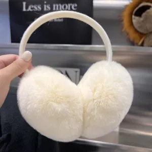 Close-up of plush white earmuffs with a wide elastic headband, held against a display backdrop