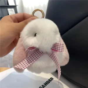 Nahaufnahme eines flauschigen weiß-rosa Hasenanhängers mit rosa Karoschleife und Metallring
