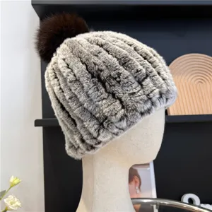 Close-up of mottled gray and brown striped fur-knit texture with a dark brown pompom